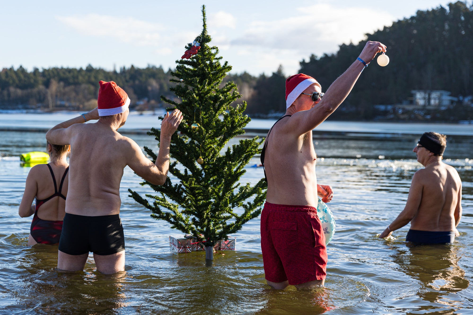 A group of people swimming in Christmas hats