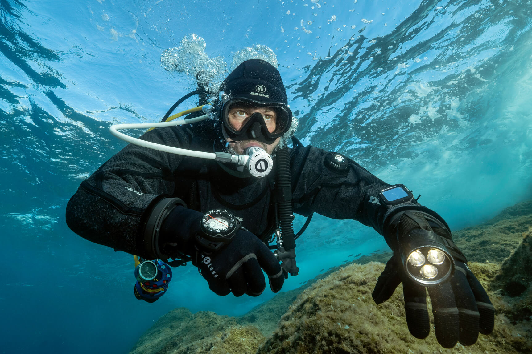 diver diving underwater in a drysuit