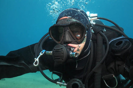 close up of diver underwater wearing a black drysuit
