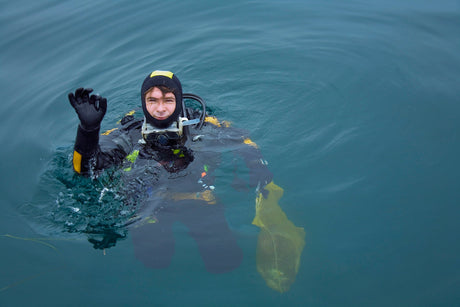 diver giving ok signal in hood and gloves for cold water diving