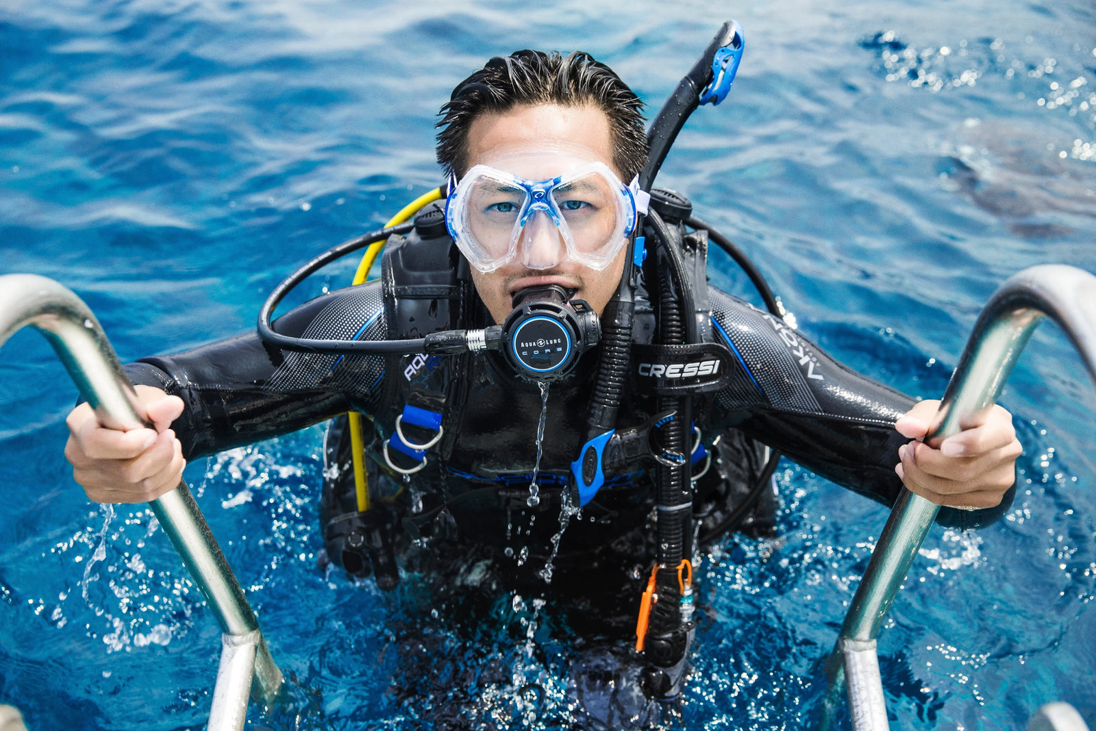 diver entering water with dive mask on 