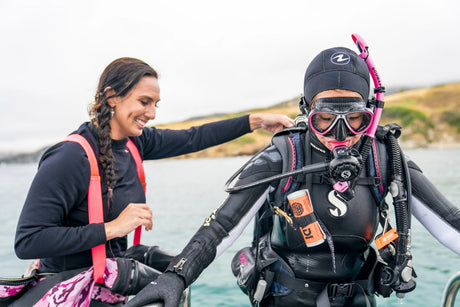 two women in the water, one is wearing a snorkel and mask